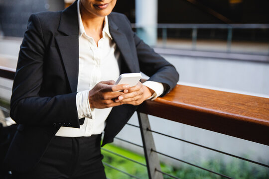 Detail of business woman using cellphone out the office building