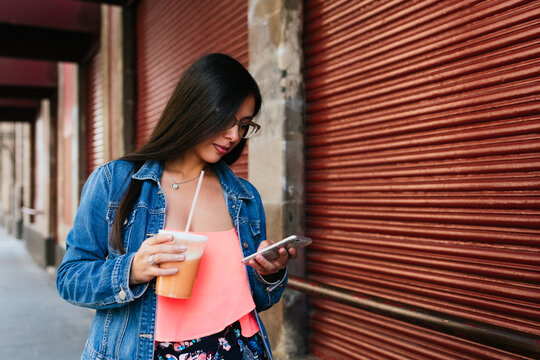 Beautiful hispanic woman scrolling on her phone