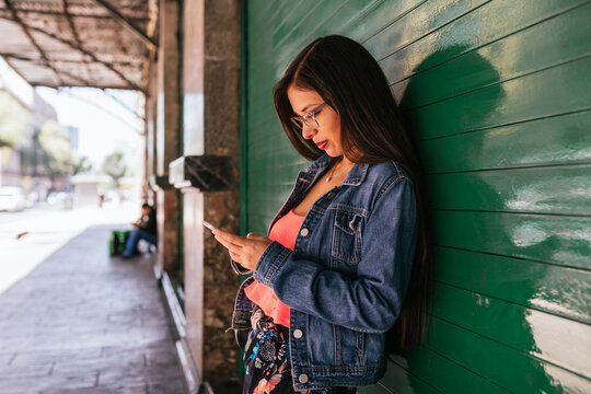 Beautiful hispanic woman scrolling on her phone