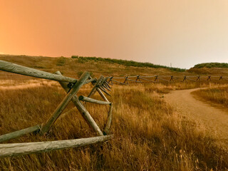 California, Oregon, Colorado wildfire orange smokey sky above rustic split log fence