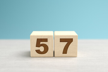 Wooden toy blocks forming the number 57.