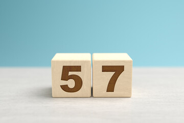Wooden toy blocks forming the number 57.
