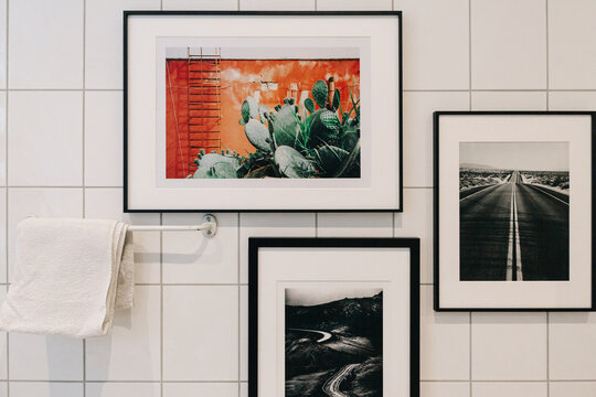White Tiled Bathroom Detail With Framed Photographs