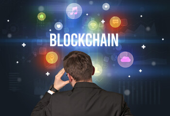 Rear view of a businessman with BLOCKCHAIN inscription, modern technology concept