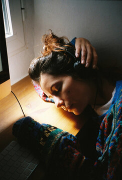 Film portrait of young tired woman in front of the computer with helmets.