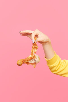 Woman dangles bitten fried chicken drumstick