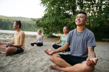 A group of yoga people in a meditative pose together.