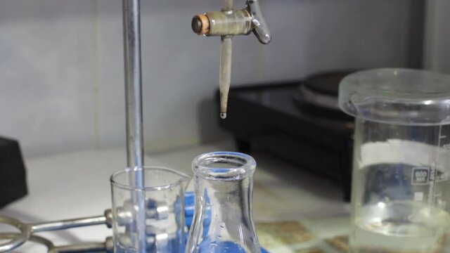 Industrial laboratory. A drop drips into a glass test tube.