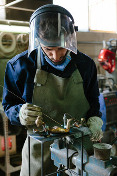 Man using a blowtorch in a foundry