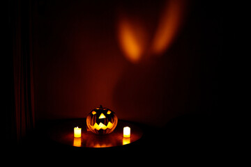 Halloween pumpkin and its reflection on the wall at night