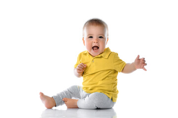 Cute laughing baby sitting on floor studio shot