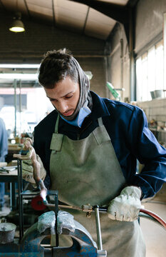 Man using a blowtorch in a foundry