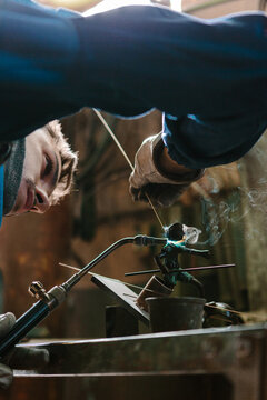 Man using a blowtorch in a foundry