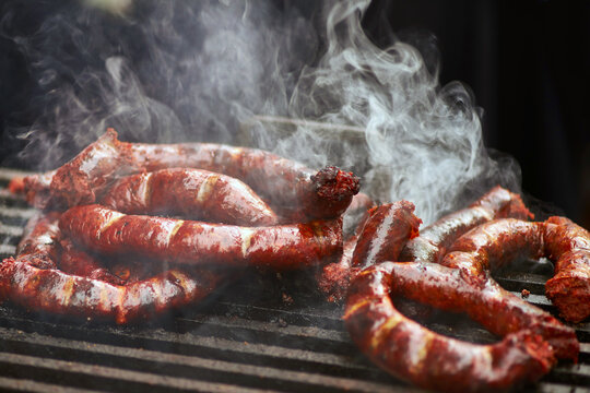 Colourful sausages cooking on grill