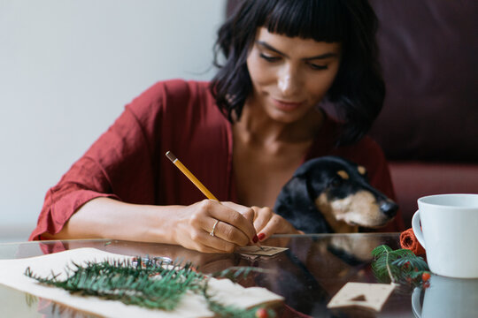Brunette woman writing a Christmas card