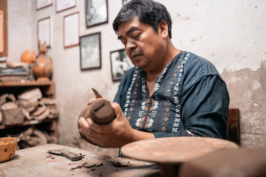Mexican artisan sculpting with mud