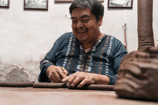 Mexican artisan sculpting with mud