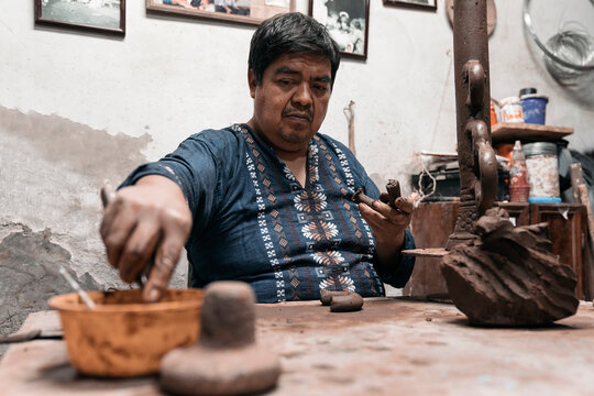 Mexican artisan sculpting with mud