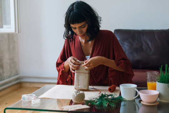 Woman wrapping Christmas gifts indoor