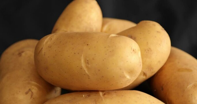 Raw Potatoes Spinning and Rotating Isolated on Black Background
