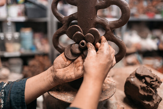 Mexican artisan sculpting with mud