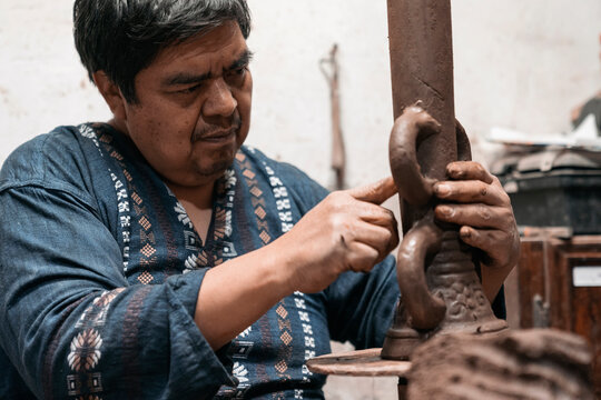 Mexican artisan sculpting with mud