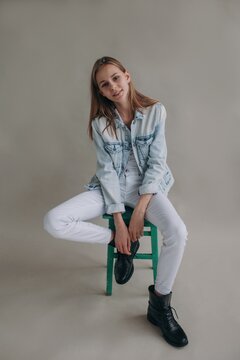 Smiling teen model sitting on stool