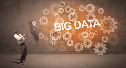 Obraz premium Businessman defending with umbrella from BIG DATA inscription, technology concept