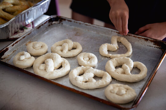 Raw uncooked pretzel dough sitting on a metal baking sheet