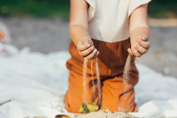 Hands of Toddler Gild Holding Sand