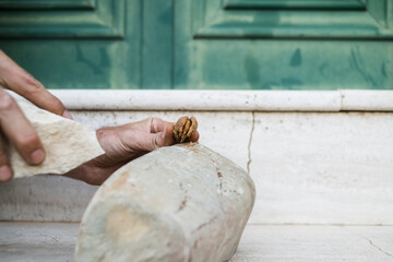 Hand opening an almond with a rock