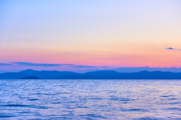 Colorful view of the sea and land on the horizon at twilight