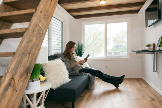 Home: Woman On Couch Reading Digital Tablet