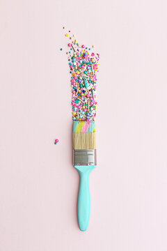 Paintbrush and colorful cake sprinkles