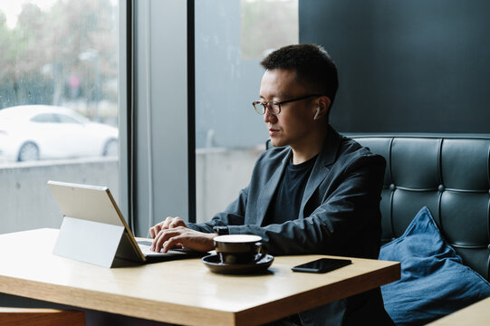 Businessman using laptop in cafeteria