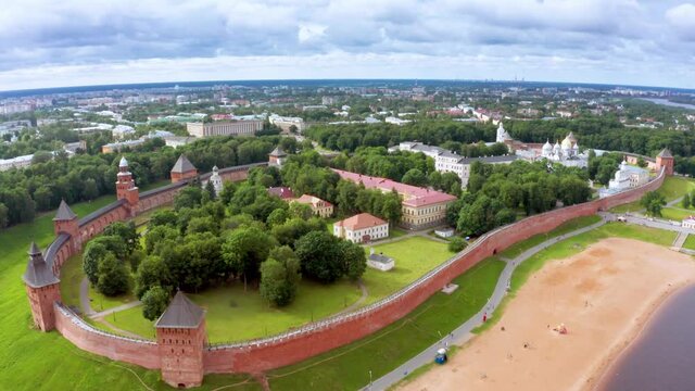 Panoramic aerial view of the Volkhov River and the old town of Veliky Novgorod, the red brick Kremlin in the rays of the setting sun and natural attractions of Russia.