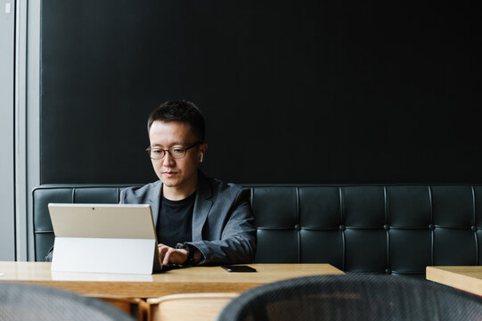 Businessman using laptop in cafeteria