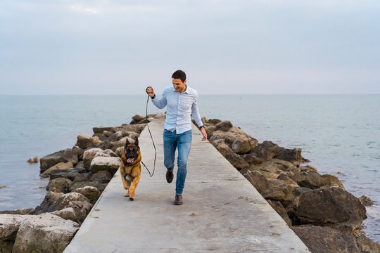 Man walking outdoor with his cute german shepherd dog