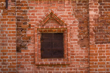 Fototapeta na wymiar Window in the wall of an old brick house
