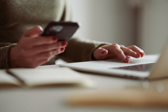 Business woman using laptop and smartphone simultaneously