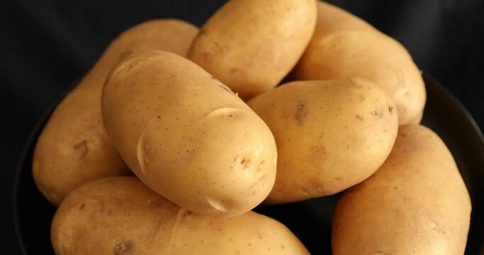Raw Potatoes Spinning and Rotating Isolated on Black Background