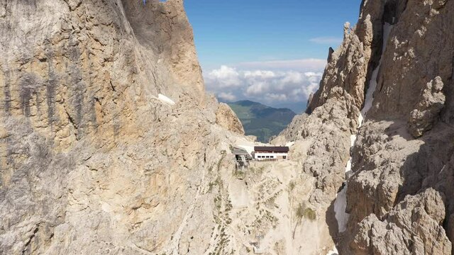 Circling around restaurant and cable car station (with very small cabins) in between Sassalungo (Langkofel) mountain range, a popular tourist detination in the Dolomites in Italy
