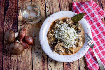 Mushroom beef stroganoff, with cremini and champignons, in a frying pan, shot from above on a dark rustic texture with a place for text