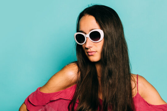 Beautiful young caucasian woman posing over blue background with color gels