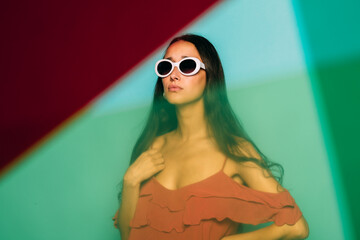 Beautiful young caucasian woman posing over blue background with color gels