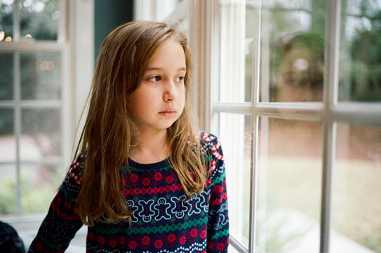 Cute young girl looking out a window
