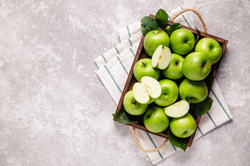 Ripe green apples in wooden box.