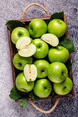 Ripe green apples in wooden box.