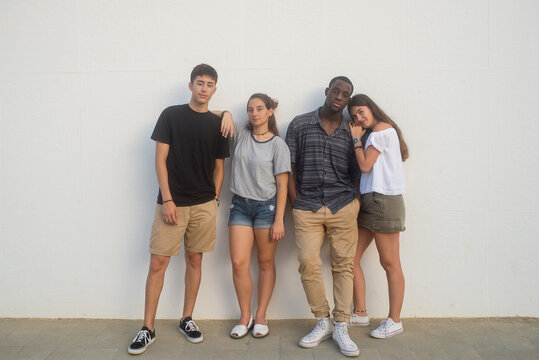 Friends posing against white wall