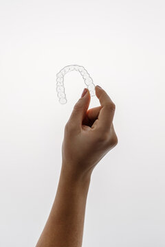 Doctor Hand Holding an Invisible Dental Aligner
